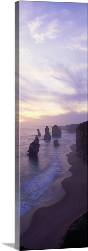Gallery-Wrapped Canvas entitled 12 Apostles Port Campbell National Park Australia .  Vertical panoramic photograph of shore with tall vertical rock formations in the ocean under cloudy skies.  Multiple sizes available.  Primary colors within this image include Sky Blue White Dark Navy Blue.  Made in the USA.  Satisfaction guaranteed.  Archival-quality UV-resistant inks.  Canvas is acid-free and 20 millimeters thick.  Canvas frames are built with farmed or reclaimed domestic pine or poplar wood.